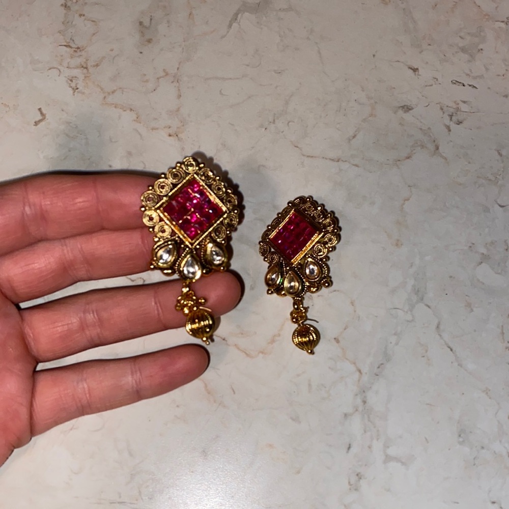 Gold dangling earrings with red gems